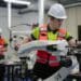 Techniker justiert Roboterarm in einer automatisierten Fertigungslinie im Bereich der modernen Automationstechnik