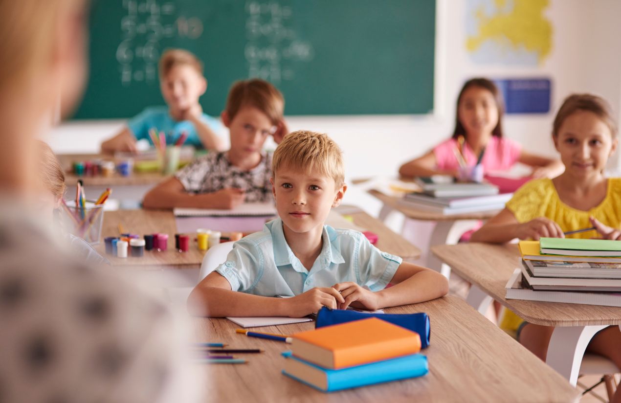 Kinder sitzen aufmerksam mit Schulmaterialien in einem Klassenzimmer der grundschule berlin